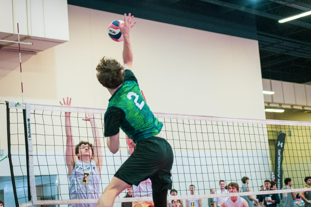 Palmetto Shore player reaching to hit the ball over the net